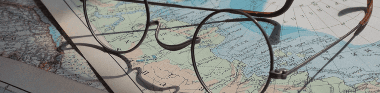 Glasses resting on a world map, symbolizing global business and remote virtual office solutions.
