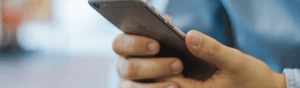 Close-up view of a man's hand with a cell phone posed for viewing