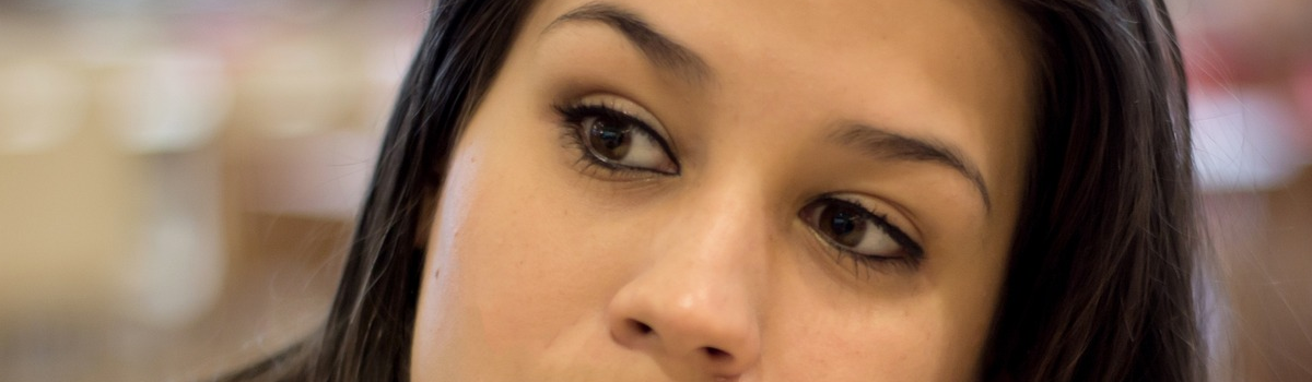 Close up of a woman's face with questioning eyes.