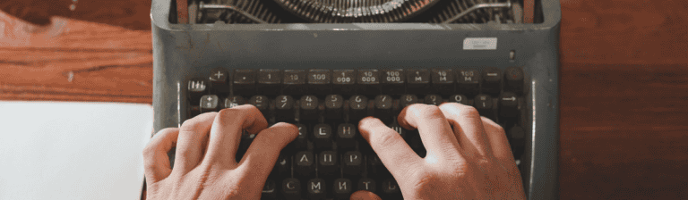 Vintage typewriter with hands typing for creative virtual office branding and remote work setup.