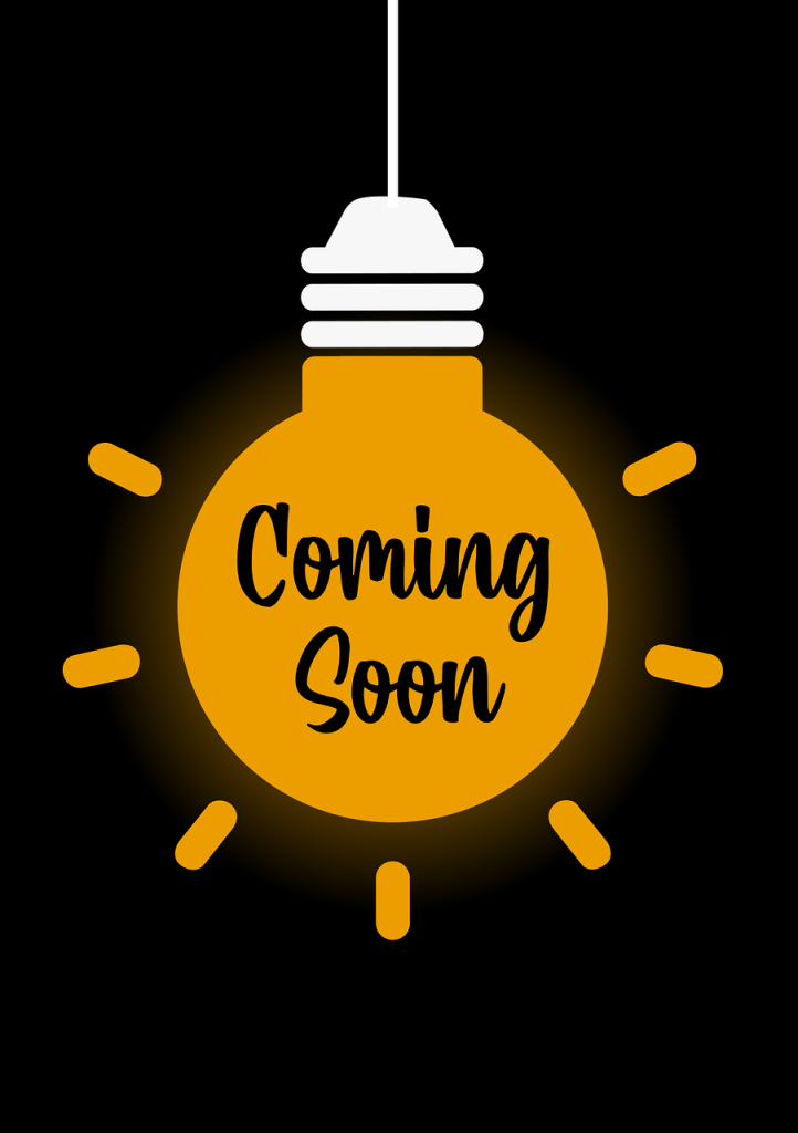 Image with a black background and an orange light bulb with the words "Coming Soon" within the light bulb.