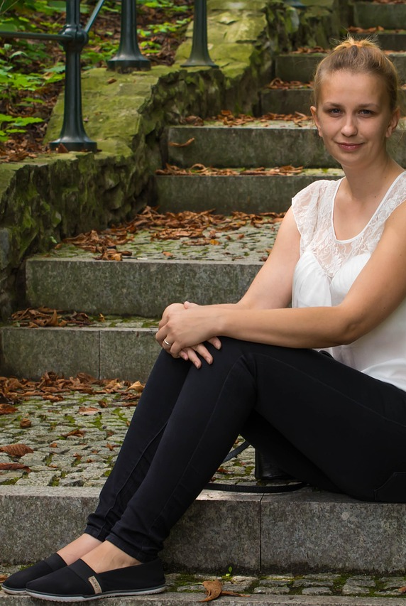 Woman sitting on steps in casual business attire.