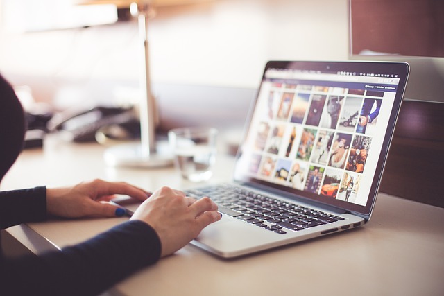 Stock image of the hands and forearms of a woman searching for images on her laptop