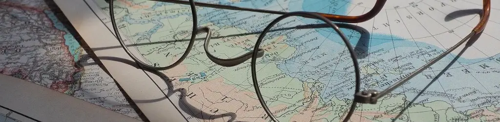 Wire rimmed glasses lay on a map