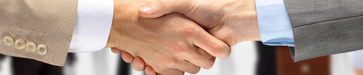 Handshake by two men, close up, suit cuffs showing